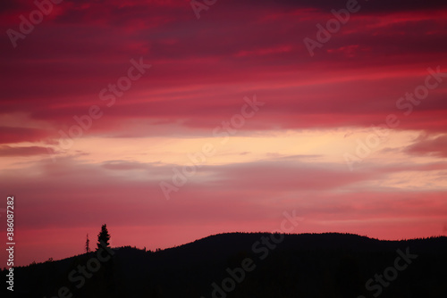 Impressive cloudscape, over the silhouette of mountain and tree