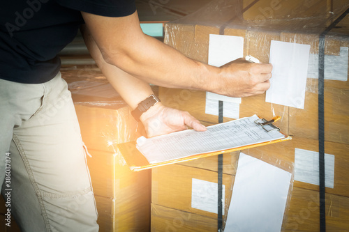 Worker courier holding clipboard his doing inventory management cargo boxes. Checking stock, Packaging, Cargo shipment boxes, Warehousing storage.