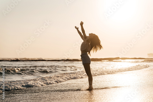Happy beach girl laughing smiling enjoying sunshine on summer vacation. Gorgeous beautiful young Chinese woman having fun.
