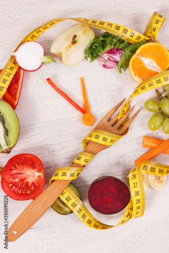 Tape measue with fruits and vegetables in shape of clock showing time to healthy eating and slimming photo