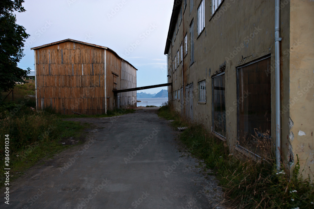 Old abandoned fishery housing and small road in Northern Norway 