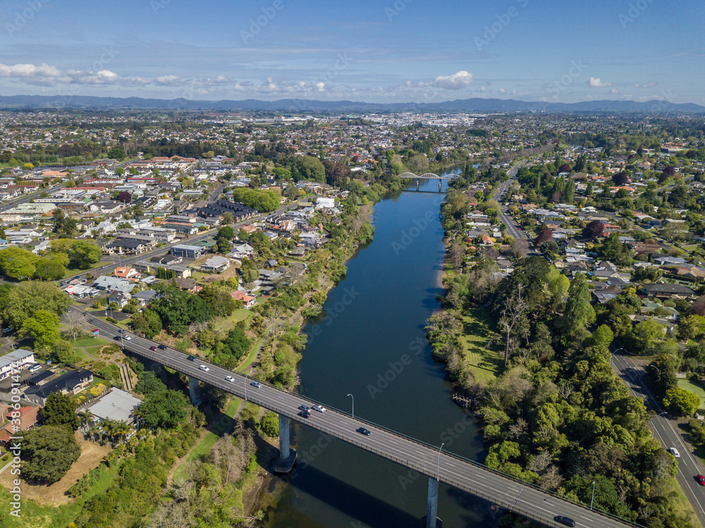 Aerial drone view looking at Whitiora Bridge over the Waikato River as it cuts through the city of Hamilton, in the Waikato region of New Zealand