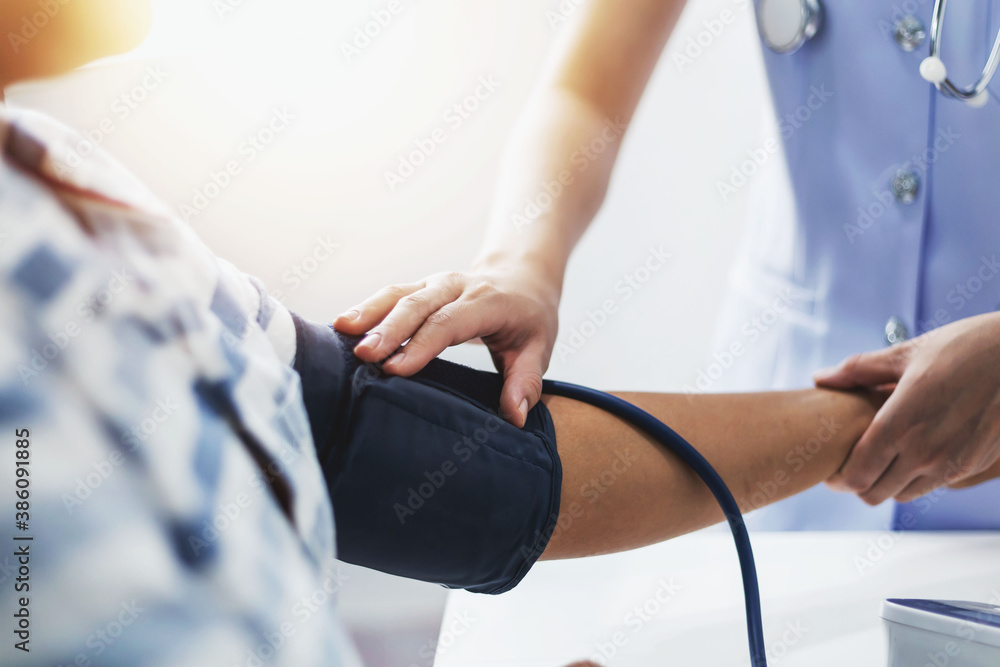 Obraz premium A young nurse is measuring the pressure of a patient who is admitted to the hospital.