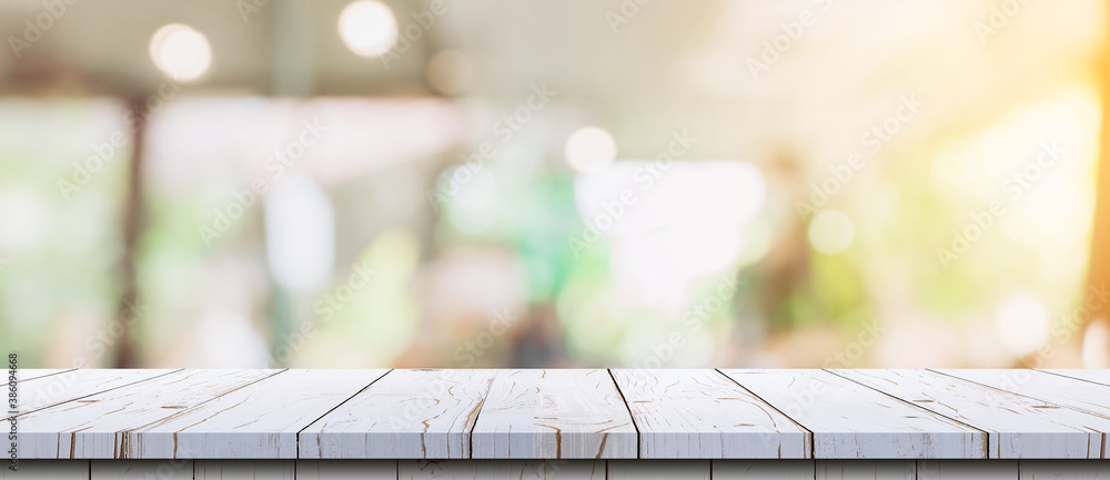 Empty wood table and blurred light table in coffee shop and cafe with ...