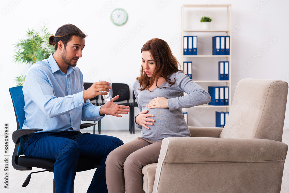 Pregnant woman visiting young male psychologist Pregnant woman visiting young male psychologist