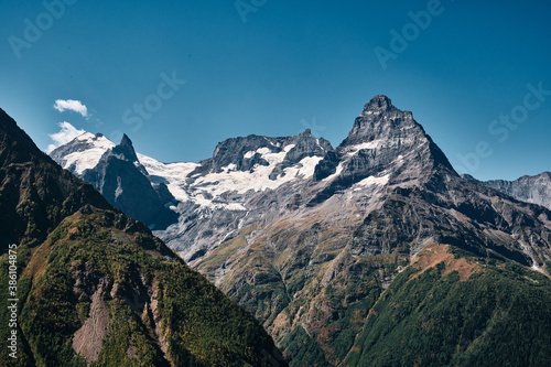 Panorama of high mountains landscape with clouds on sky. Rocks.