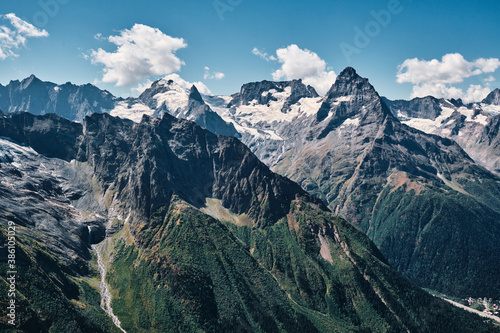Panorama of high mountains landscape with clouds on sky. Rocks.