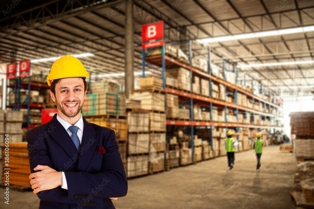 Portrait of business caucasian warehouse worker standing in large warehouse distribution center with arms crossed. Portrait of business caucasian warehouse worker standing in large warehouse distribution center with arms crossed.