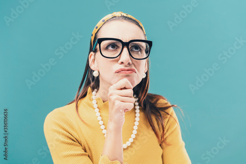 Tableau sur toile Confused clueless woman thinking with hand on chin