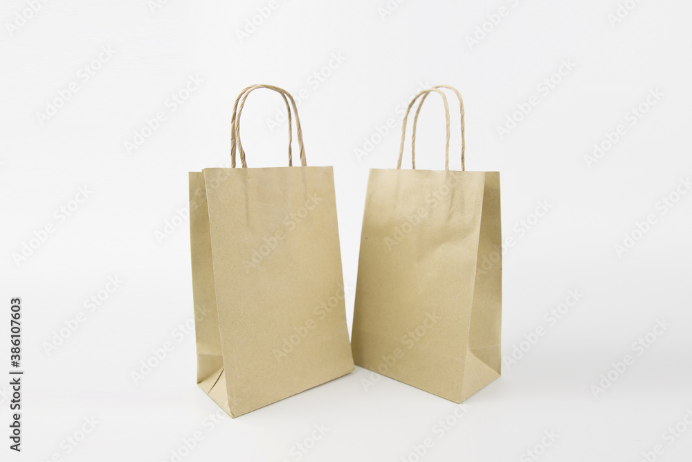 Close-up the paper shopping bag blank or without logo isolated on a white background. Close-up the paper shopping bag blank or without logo isolated on a white background.