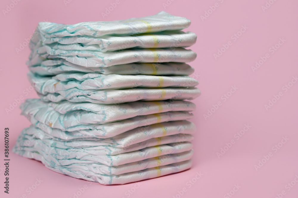 stack of diapers on a pink background, baby hygiene products stack of diapers on a pink background, baby hygiene products