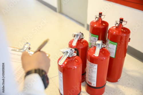 Fire fighter are checking the red fire extinguishers tank in the building concepts of fire prevention emergency and safety rescue of fire services and training.