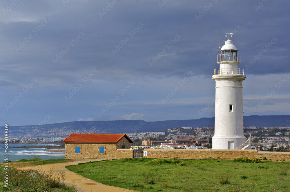 Lighthouse on the coast of state country. View of the lighthouse and Paphos in early spring. Lighthouse on the coast of state country. View of the lighthouse and Paphos in early spring.