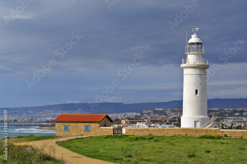 Lighthouse on the coast of state country. View of the lighthouse and Paphos in early spring.