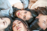 Top view self portrait of attractive pretty girls friends group lying on white bed talking scret