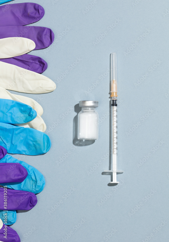 Vaccination and immunization concept syringe with ampoules, colored gloves Vaccination and immunization concept syringe with ampoules, colored gloves