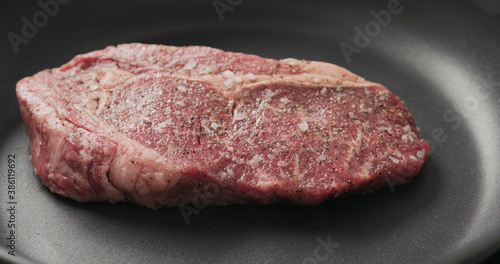 Closeup shot of ribeye steak frying on non stick pan