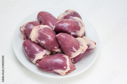 Fresh raw turkey hearts on a plate. Bird giblets ready for cooking.