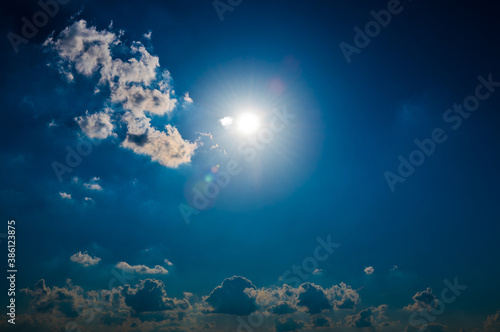 Sun and clouds in the dark blue sky (backlight)