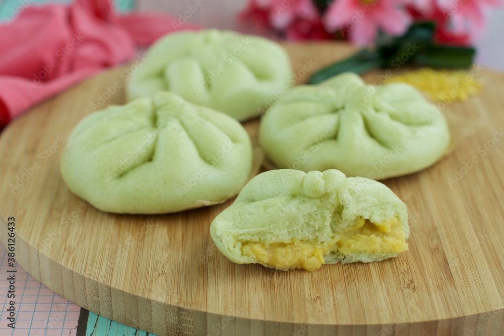 Fresh steamed Pandanus bread buns, filled with mung bean paste on wooden board, selective focus