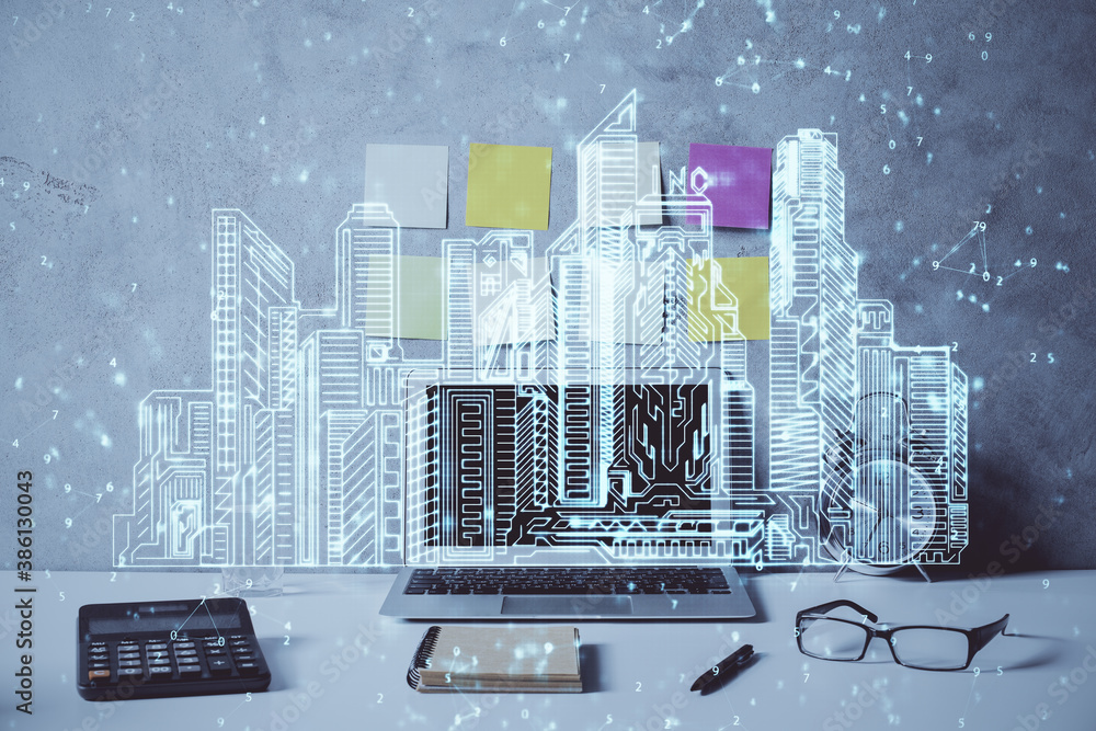 Desktop computer background in office and big town buildings hologram drawing. Double exposure. Smart city concept. Desktop computer background in office and big town buildings hologram drawing. Double exposure. Smart city concept.