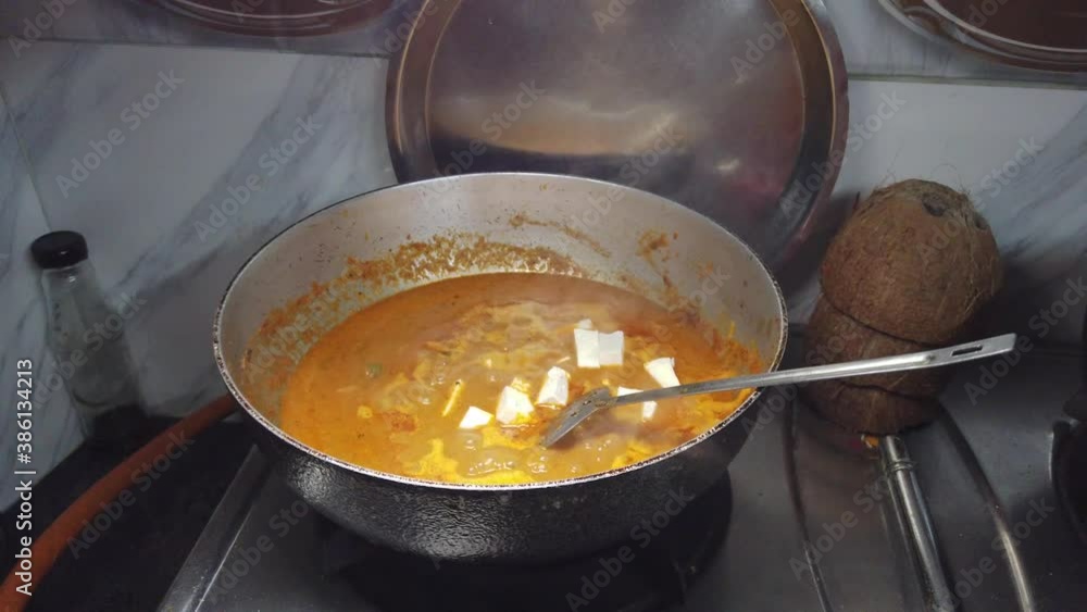Putting homemade paneer blocks in spicy gravy for dinner Putting homemade paneer blocks in spicy gravy for dinner
