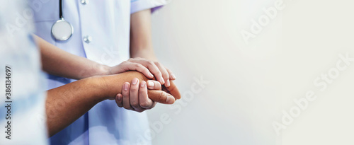 A nurse shaking hands to encourage the patient