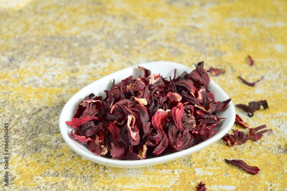 Dried hibiscus tea on yellow background Dried hibiscus tea on yellow background