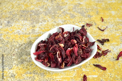 Dried hibiscus tea on yellow background