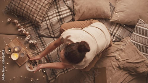 From above stab shot of young female making notes in diary while having healthy breakfast in cozy room