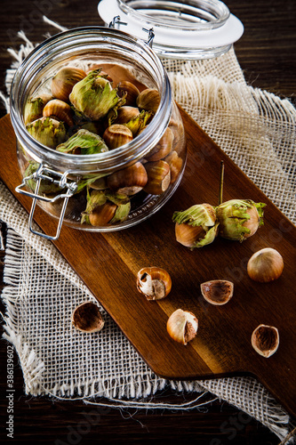 Ripe hazelnuts in shells on wooden table 