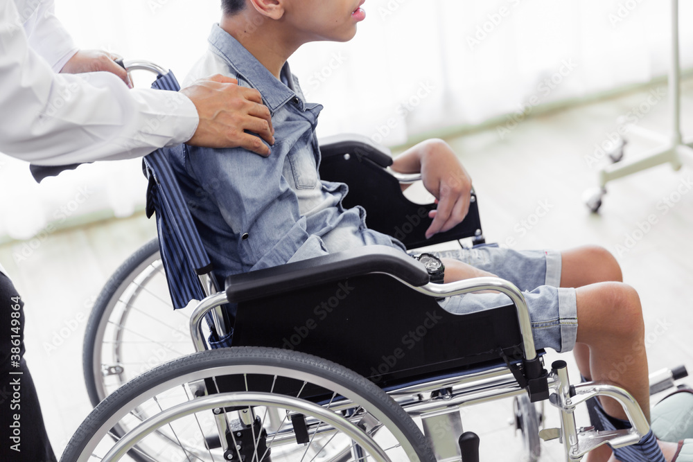 Obraz premium Closeup doctor hand with disability patient on wheelchair