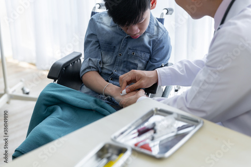 Asian Doctor checking and treatment wheelchair disability patient