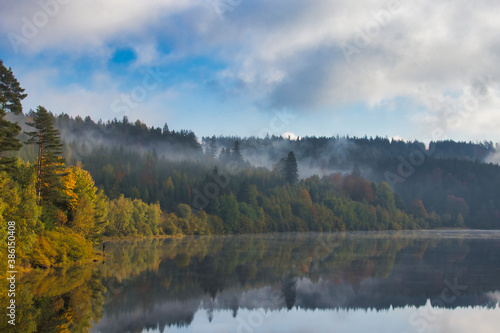 Lake with reflection at a Morning in autumn with a fisher