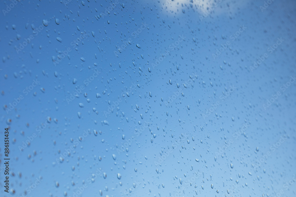 Clear blue sky view through a window with rain drops on the glass. Clear blue sky view through a window with rain drops on the glass.