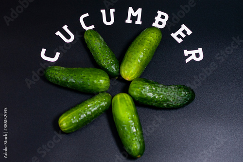 Fresh green cucumbers lie star - shaped in a circle. Copy space