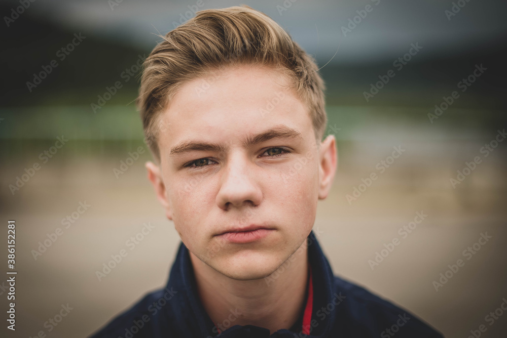 Fototapeta premium boy with stylish hairstyle outdoors. Looking at camera. Teenage boy