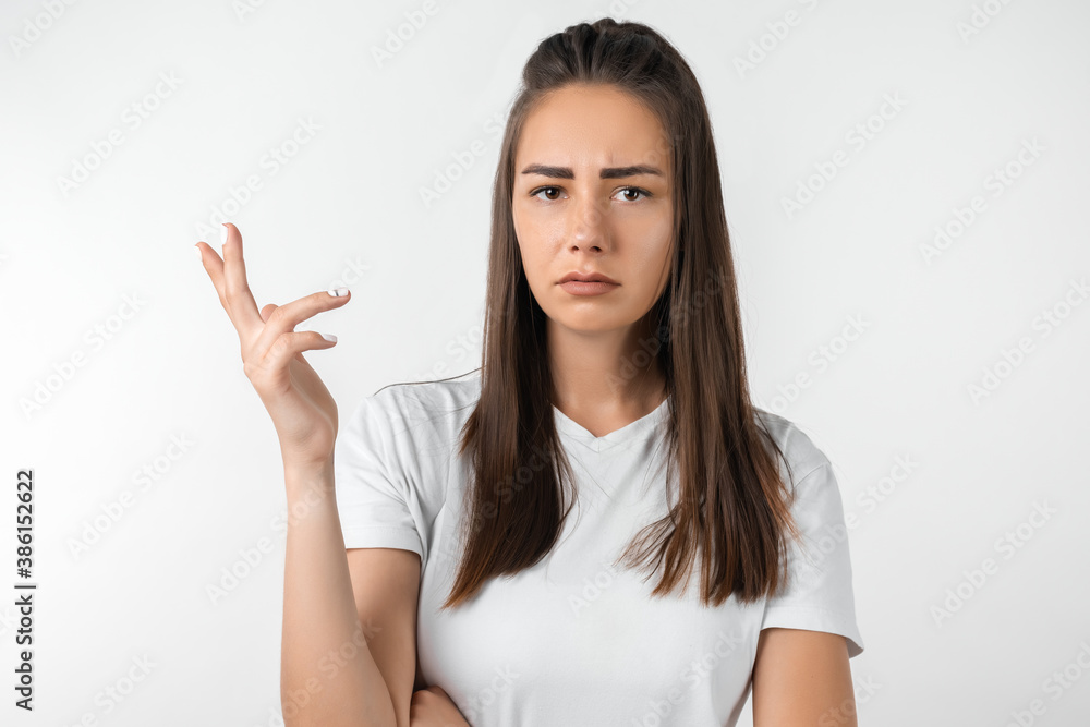 Portrait of confused girl pointing hand in sides. Studio shot, white background. Concept of doubt and uncertainty Portrait of confused girl pointing hand in sides. Studio shot, white background. Concept of doubt and uncertainty