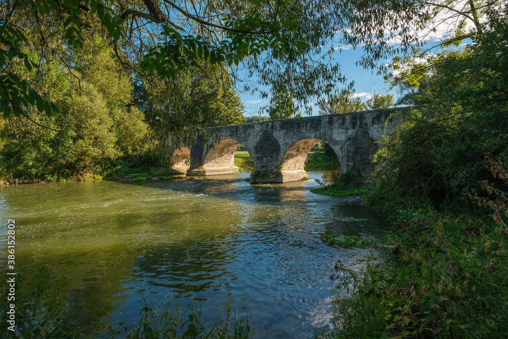 Historische Steinbrücke über die Altmühl bei Pfünz, Blick zwischen Äste und Zweige am Ufer Historische Steinbrücke über die Altmühl bei Pfünz, Blick zwischen Äste und Zweige am Ufer