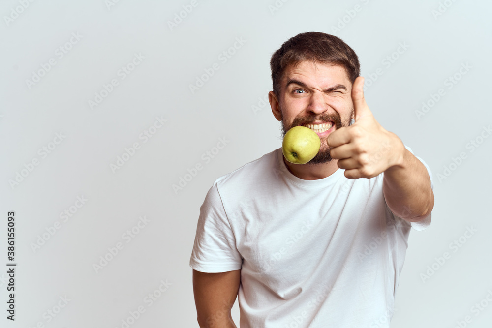Energetic man with apples health vitamins diet and lifestyle white t-shirt cropped view Energetic man with apples health vitamins diet and lifestyle white t-shirt cropped view