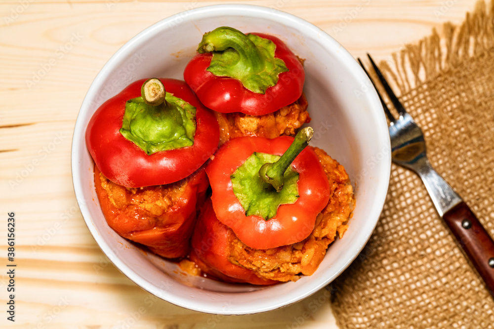red pepper stuffed with meat and bulgur in a white plate on a wooden table red pepper stuffed with meat and bulgur in a white plate on a wooden table