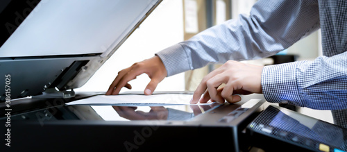 Tableau sur toile Business man Hand press button on panel of printer, printer scanner laser office