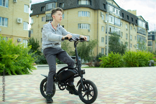 A teenager rides around the city on an electric bike.