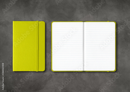 Lime green closed and open lined notebooks on dark concrete background