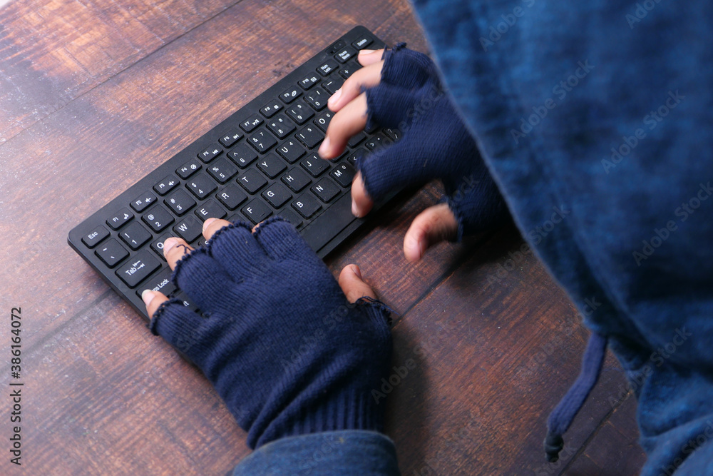 Fototapeta premium hacker hand stealing data from laptop top down