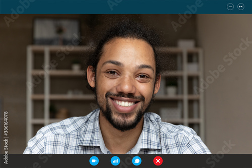 Head shot portrait screen view smiling African American man talking online, looking at camera, chatting with friends or relatives at home, using webcam and social media app, video call concept