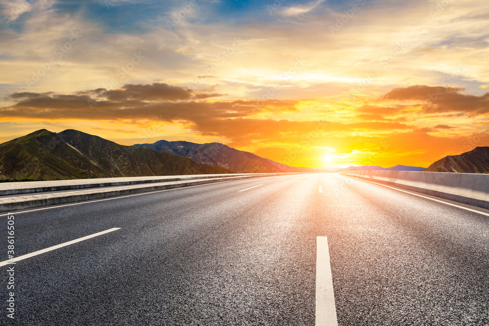 Asphalt road and mountain with sky cloud natural scenery at sunrise.