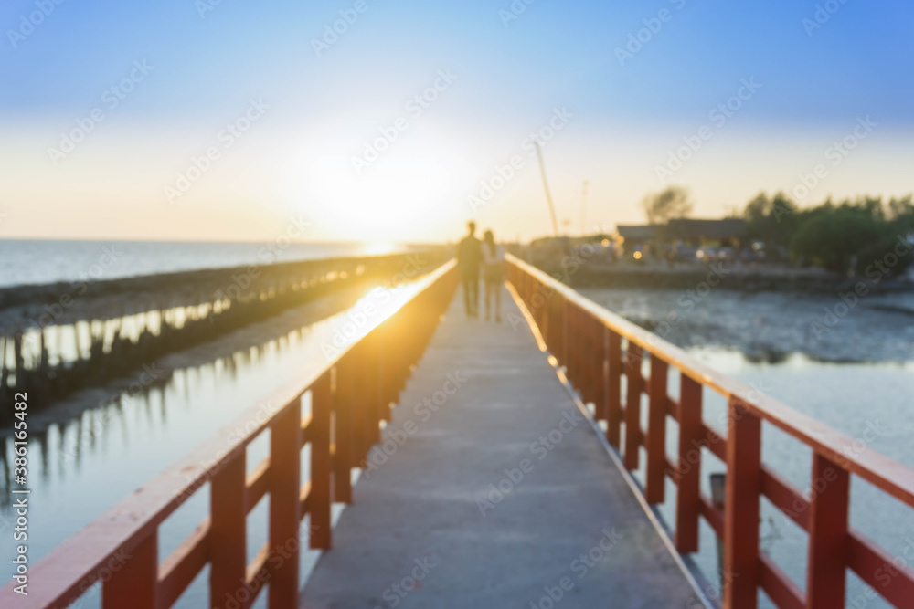 Tourists on wooden bridge, below the sea, sunset view.