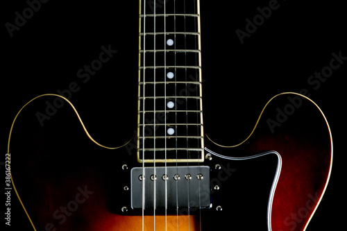 Semi Acoustic Electric Guitar Partial Body and Neck on a Black Background