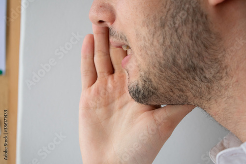 Close-up of a young man whispering something